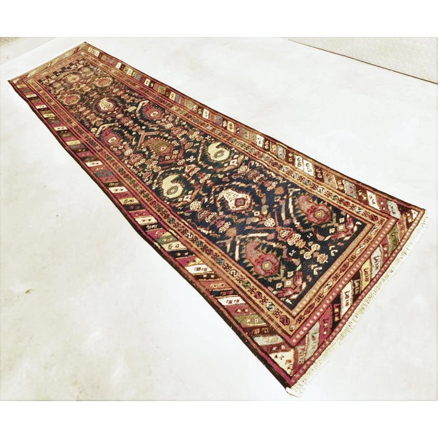 Stylized paisly design along with intricate motifa on blue background, within barber pole border. Hand knotted. wool pile...