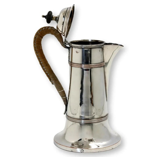 Refined and understated, this antique English coffee pot embodies the elegance of early 20th-century silver service....