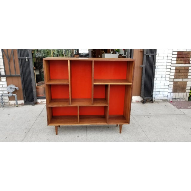 Stunning, custom made bookcase with solid walnut legs, premium grade American made walnut plywood and custom orange...