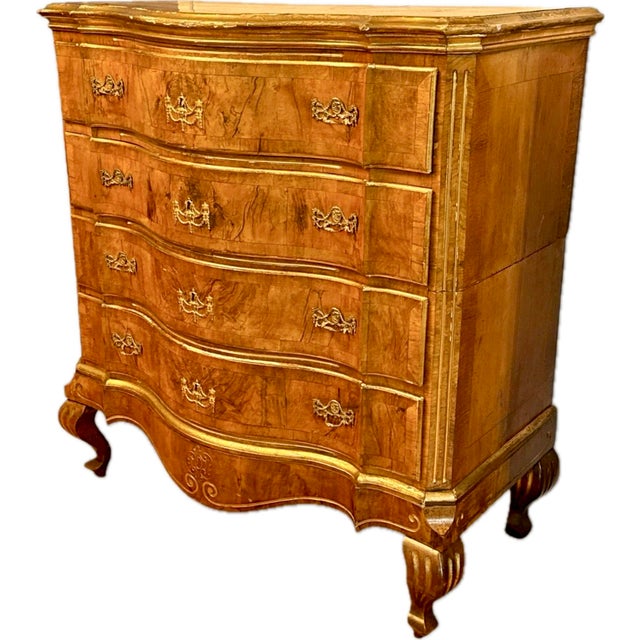 Stunning German Baroque Commode with serpentine front in burled walnut and elevated with hand-applied gilding that...