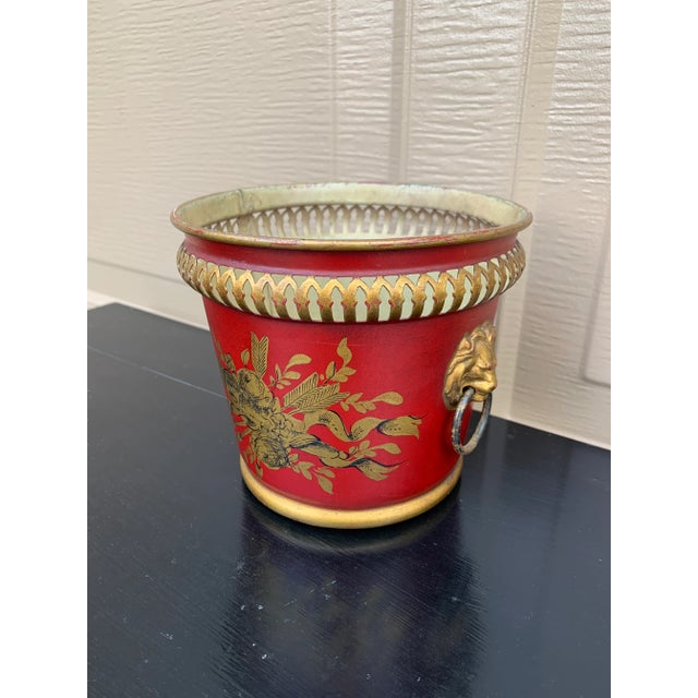 A wonderfully charming early 20th century French tole cachepot finished in a rich cinnabar red with delicate gilt...
