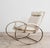 Rocking Armchair ATTR. Guido Faleschini 1970s Hollywood Regency Design. All-metal structure painted gold. Vain-colored...