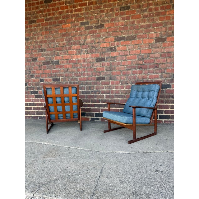 Pair of mid-century lounge chairs by Selig. These chairs feature solid walnut frames with an open lattice back design and...