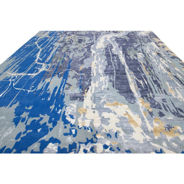 This contemporary hand-knotted rug showcases a stunning abstract design in vibrant colors that effortlessly captures...