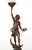 Art Nouveau style newel post table lamp made of dark stained wood and an opaline flame glass shade. The statue depicts a...