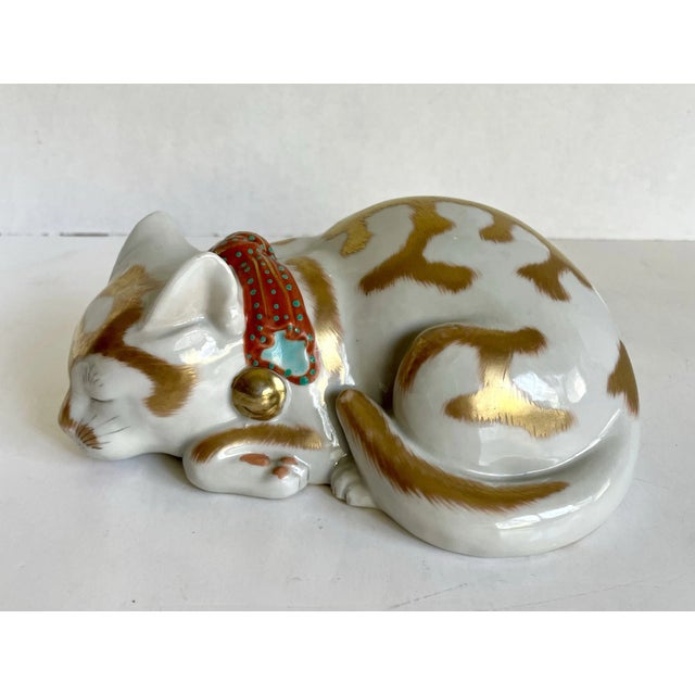 Here is a beautiful Japanese Kutani fine porcelain figure of a cat, curled into a sleeping position. It is called nemuri...