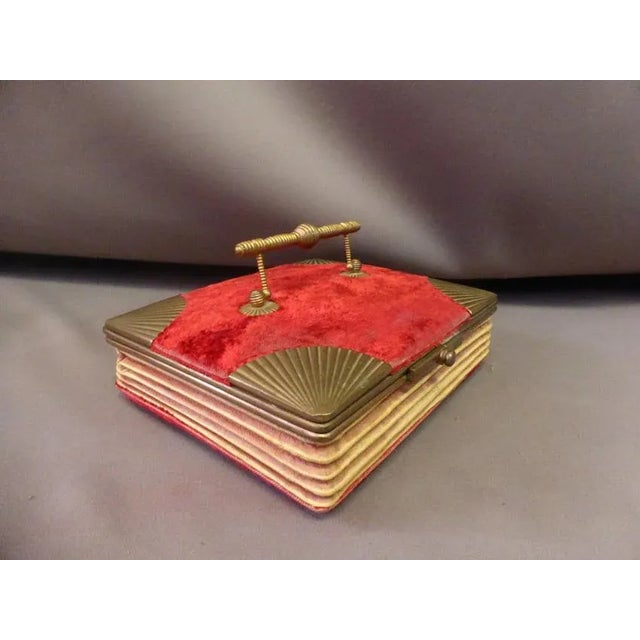 Set of one glove box and one jewellery box assorted. They are made of red velvet and brass, the handle is mobile. On the...