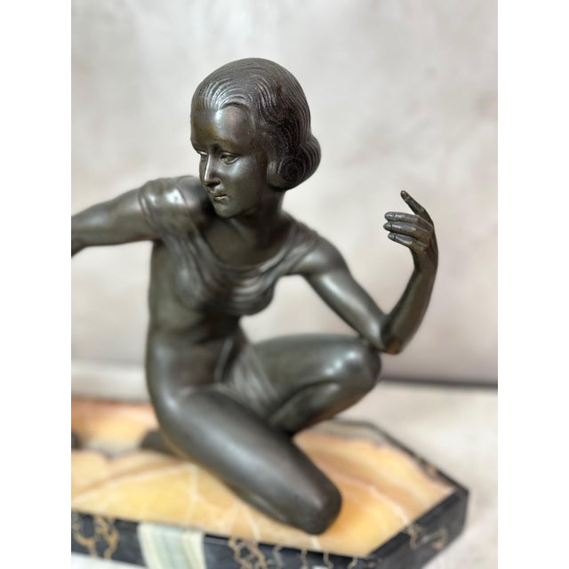 An elegant Art Deco sculpture depicting a stylized young woman accompanied by a gazelle, in a composition full of grace...