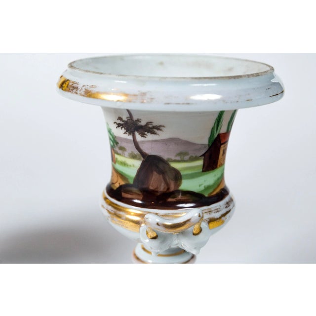 Pair Old Paris porcelain urns, France, 19th Century. Hand-Painted classical form urns. A different landscape scene on each...