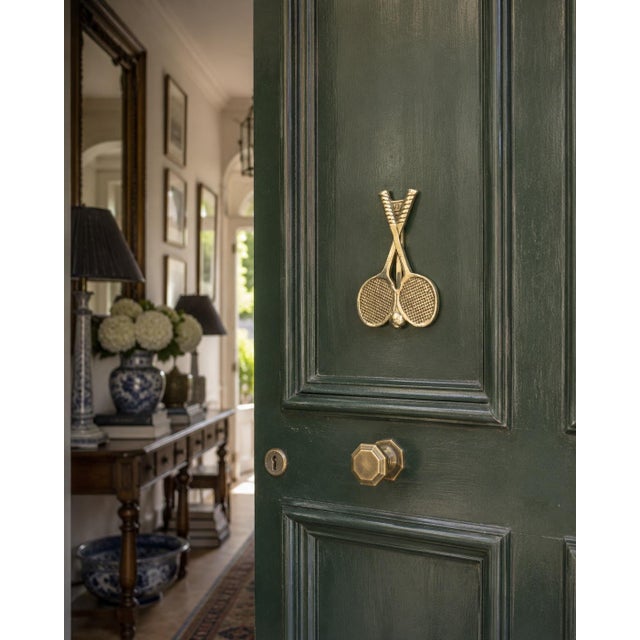 A charming late 20th-century door knocker cast in brass and modeled as a pair of crossed tennis rackets with a dimensional...
