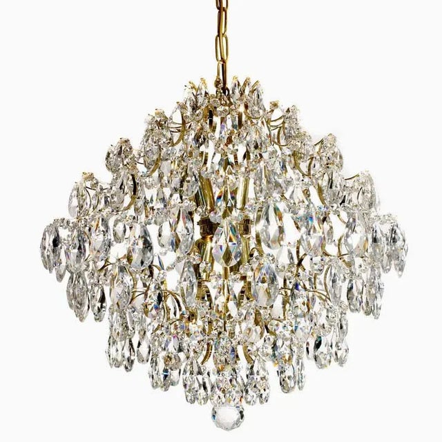 Polished brass and crystal modern style chandelier . On the inside of the frame are 6 electric light bulbs which shine...