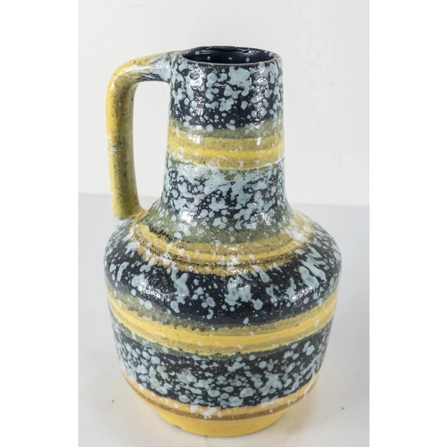 We are selling this very attractive mid century pottery vase. This vase has nice yellow and blue decoration with white...