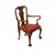 A Chippendale style armchair in walnut with a distressed finish and elaborately carved knees and ball and claw feet.
