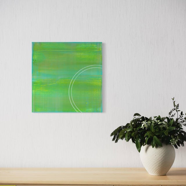 Cool sage green replaces the warmer tones of its companion pieces here, a single traced circle resting within a softly...