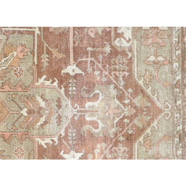 This semi-antique Persian Heriz rug, measuring 9'9" by 11', is handwoven in Iran's Mahal region and has been carefully...