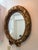 Elegant vintage style oval wall mirror with ornate antique gold finish and decorative bow detail. Made by Pinnacle Wall...