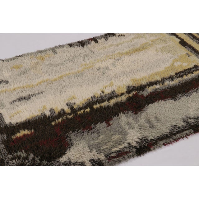 Hand-knotted in lush, high-pile wool in Sweden circa 1960-1970, this 4x7 vintage Swedish Rya rug is a bold new addition to...