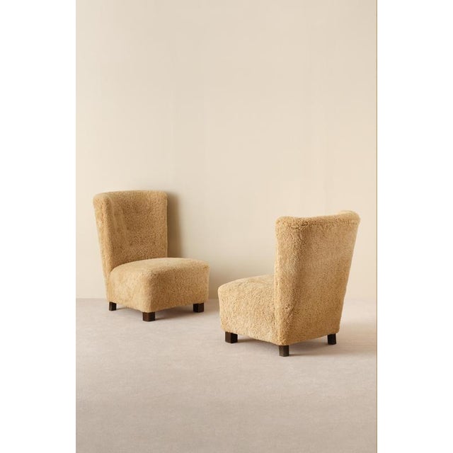 Excellent condition. Newly reupholstered in honey colored sheepskin.