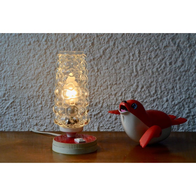 Definitely midcentury, this little lamp 50s has a killer design. Unusual, colorful, warm, unclassifiable and endearing, it...