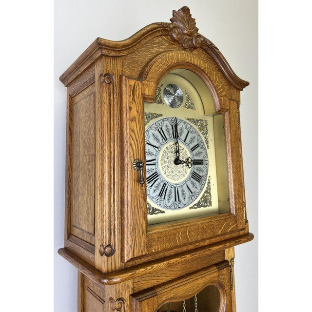 A charming Vintage French grandfather clock crafted in oak with elegant traditional styling and beautiful decorative...