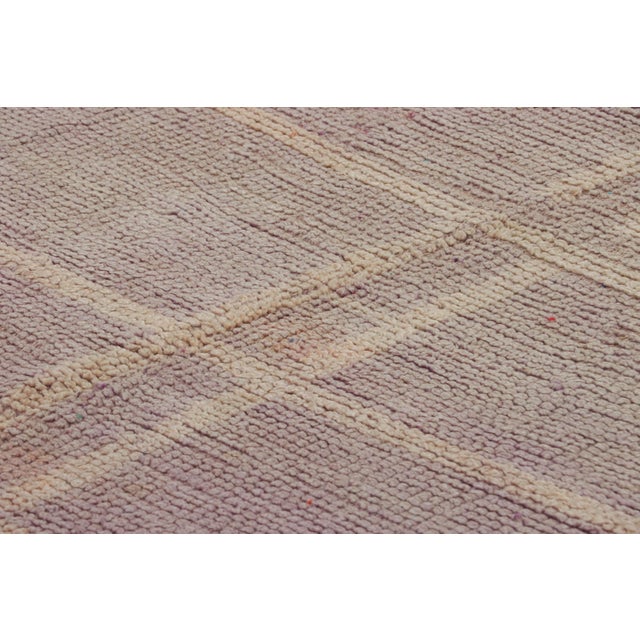 Hand-knotted in wool and originating from Morocco circa 1950-1960, this 7x9 vintage rug is a rare and among the most...