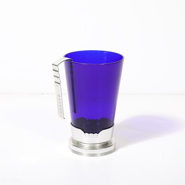 This strikingly elegant Art Deco ice bucket, crafted in blue glass with an aluminum base and accompanying tongs, is a...