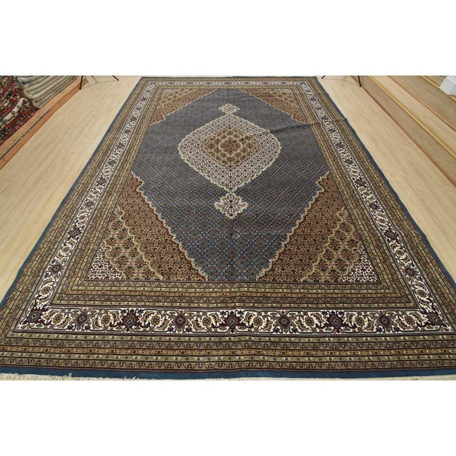 This traditional Tabriz Mahi rug is hand-knotted with an all-wool pile on a cotton foundation. This finely woven oriental...