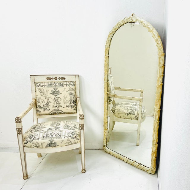 An arched vintage mirror framed in sculpted palm leaves finished in creamy lacquer with a beautifully aged patina. The...