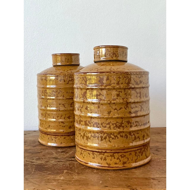 This sophisticated pair of vintage ceramic urns offers a stunning exploration of texture and tone, characteristic of the...