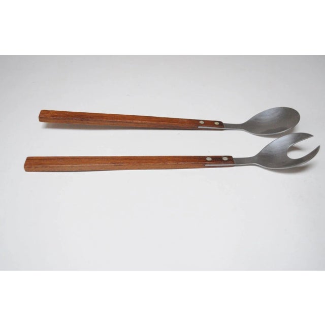 Vintage set of salad tongs in stainless steel and rosewood (ca. 1960s, Japan). Modernist design with crescent-form...