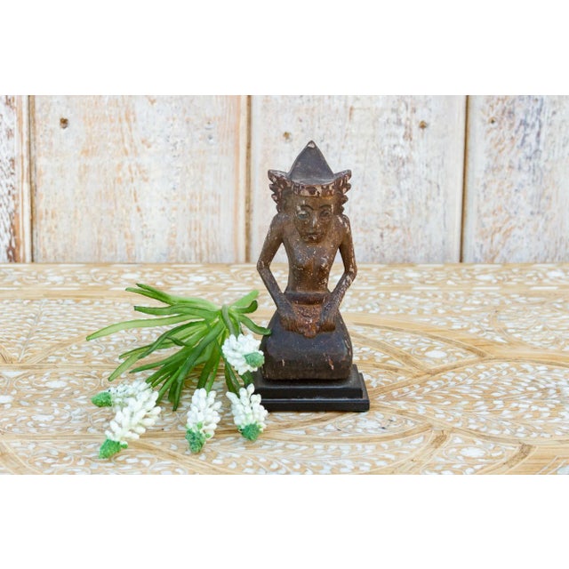 A small graceful antique Balinese figurine of a man in prayer position. This antique devotional figure is carved from wood...