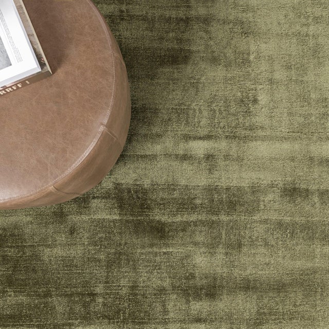 Soft luxurious olive green silk-like viscose-cotton rug. Lightly distressed finish for texture and dimension. Available in...