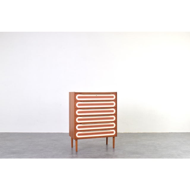 This Danish chest of drawers from the 1960s is an intriguing mix of classic Scandinavian design with a unique,...