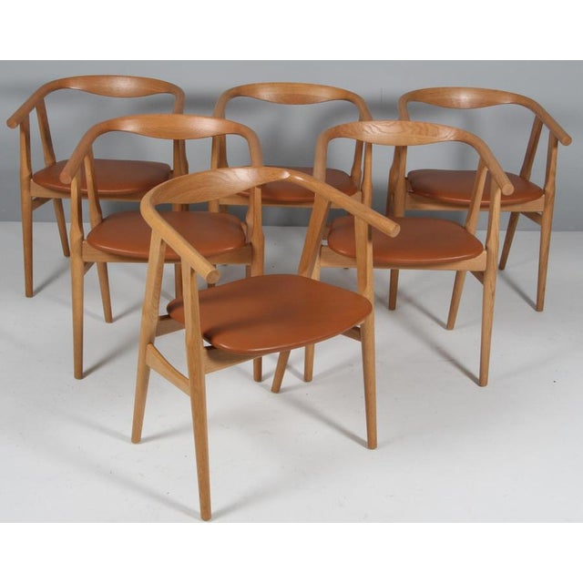 Hans j. Wegner armchairs in massive new renovated soap treated oak new upholstered with black semi aniline leather. Model...