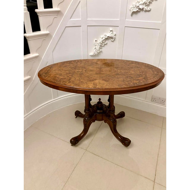 Antique Victorian quality burr walnut inlaid oval lamp table having a quality inlaid burr walnut oval shaped top with a...