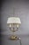 The bouillotte lamp takes its name from a French card game played late into the evening, when a table needed steady light...