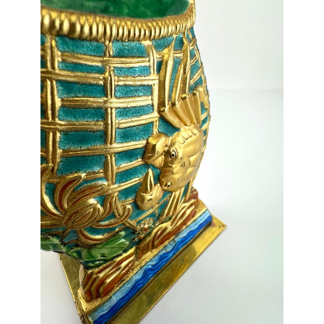 A vibrant pair of vintage bookends featuring raised fish motifs in rich gilt against a textured ground of turquoise, jade,...