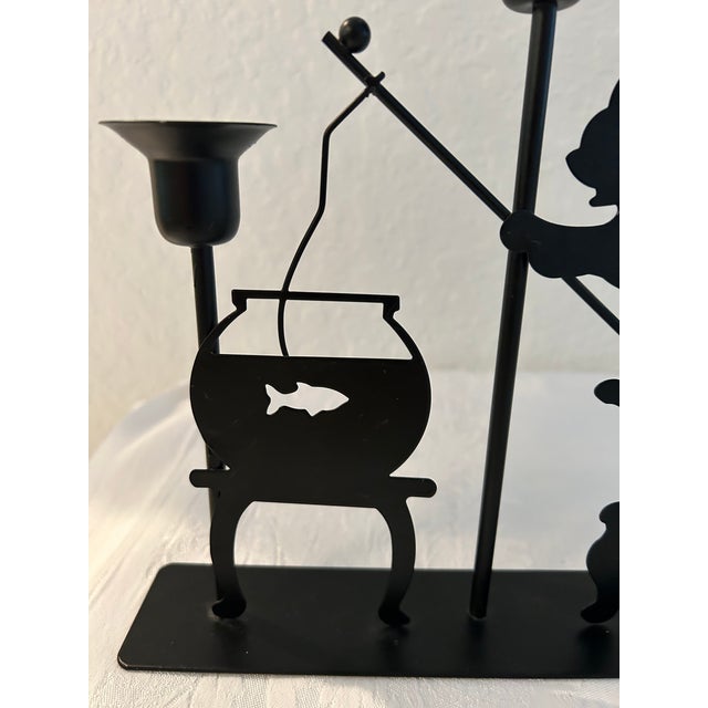 Charming 1980s black metal triple candleholder featuring a cat fishing out of a fishbowl. Excellent condition. Holds three...