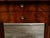 A pair of French Empire period walnut veneered console tables from the early 19th century, with dark grey marble tops,...