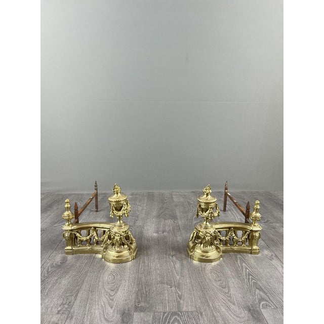 Beautiful pair of Louis XVI style gilt bronze andirons, richly decorated with garlands, ribbons, flaming urns, and lion...