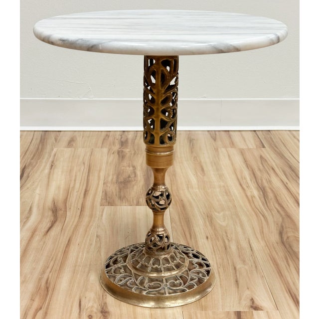 Classic vintage French style brass filigree base table with round marble top. Marble top features gorgeous veining....