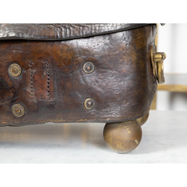 An antique English leather case from the 19th century, with GR crowned monogram, brass handles and petite ball feet....