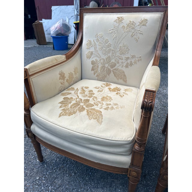 A striking, heirloom-quality pair of French Louis XVI Revival style bergère armchairs. These sophisticated accent chairs...