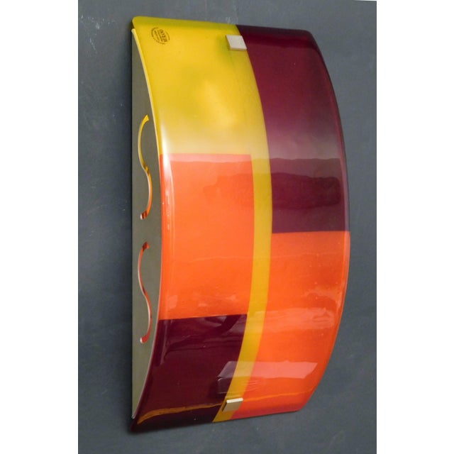 Vintage Italian wall light with curved Murano glass shade in yellow, orange and red colors, mounted on gold metal frame /...