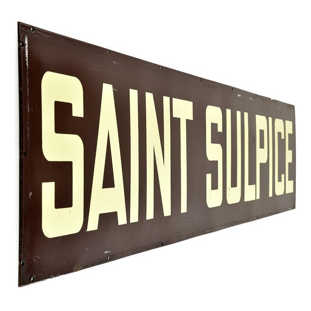 Evoking another era, this large old enamelled plaque bears the inscription "saint sulpice" in beige capital letters on a...