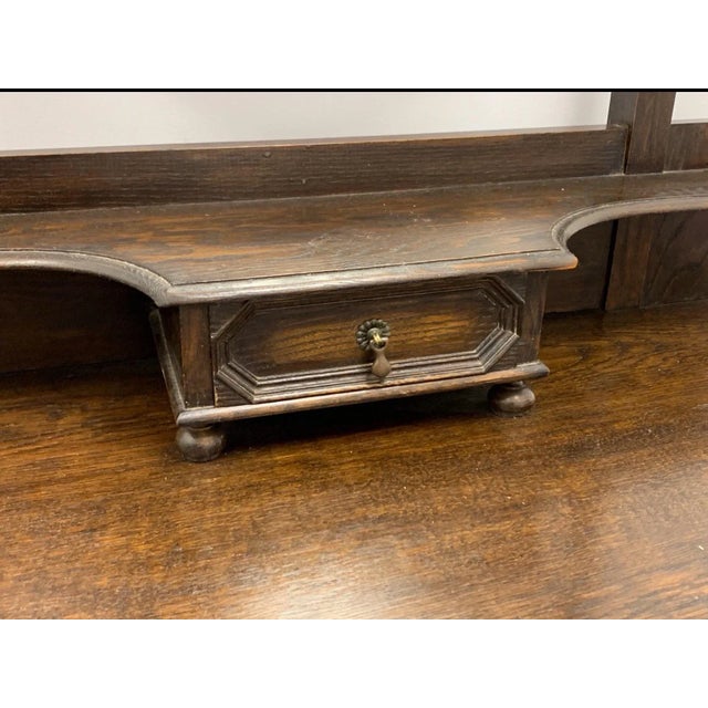 This is an antique English oak vanity or commode with barley twist form supports. The mirror lifts out of its frame. The...
