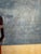 Striking vintage oil painting on canvas depicting a stylized African tribal figure standing against a simplified desert-...