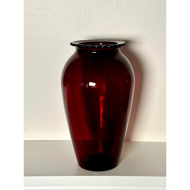 A deep rich ruby red color exudes from this clear glass vase. It’s bulbous shape with scalloped flat rimmed top makes it a...