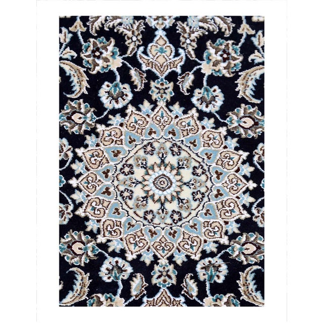 Persian Nain rugs are renowned for their detail and fine use of outlining along the central motifs. Breaking from the...
