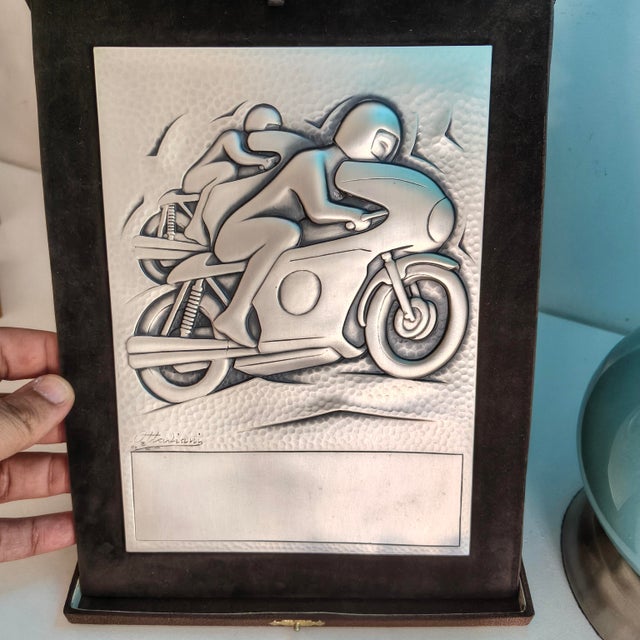 Feel the adrenaline rush and the passion of the racetrack through this remarkable piece. This vintage commemorative plaque...